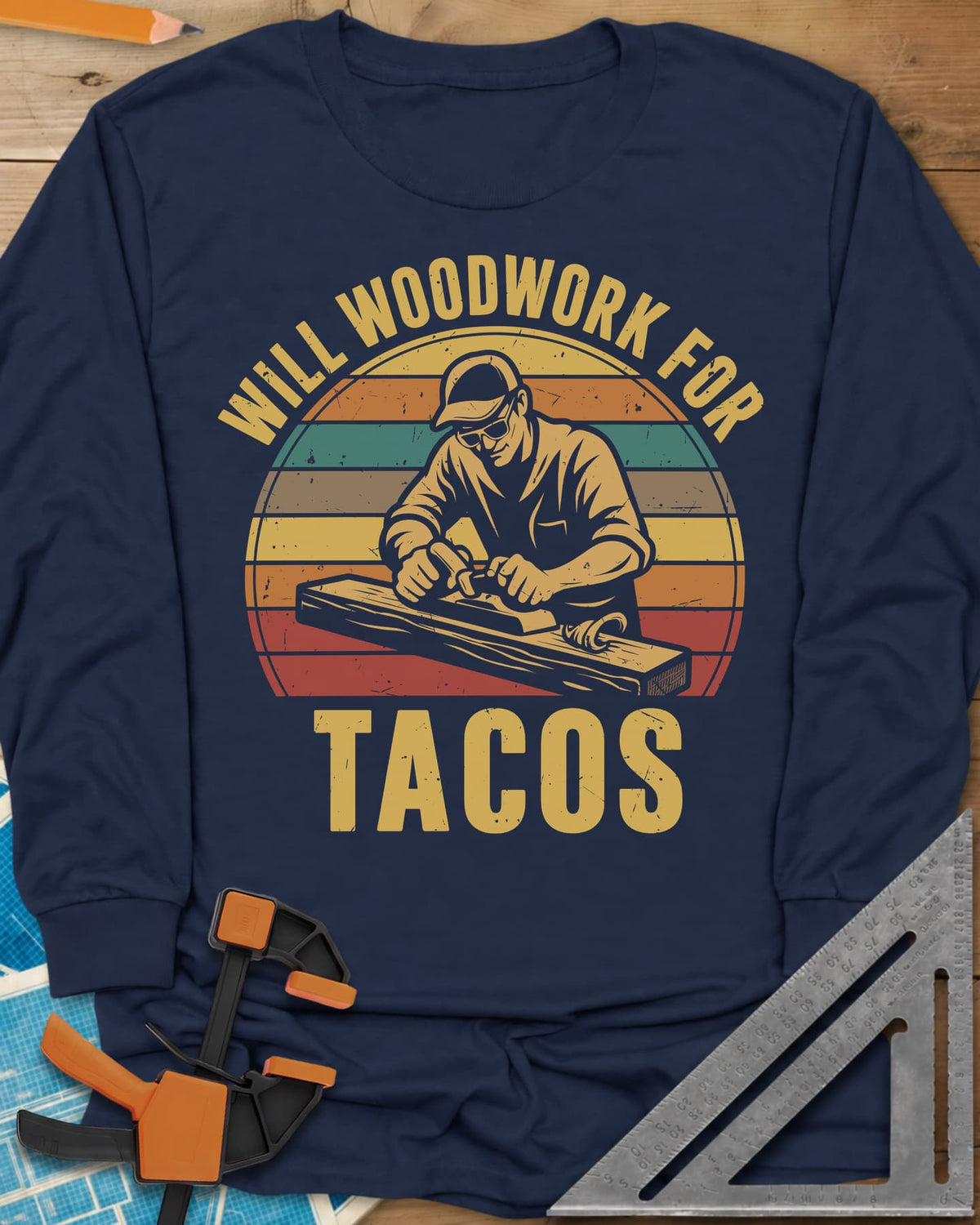 Will Woodwork For Tacos long sleeve shirt in Navy, a capped woodworker planing a board before retro sunset stripes
