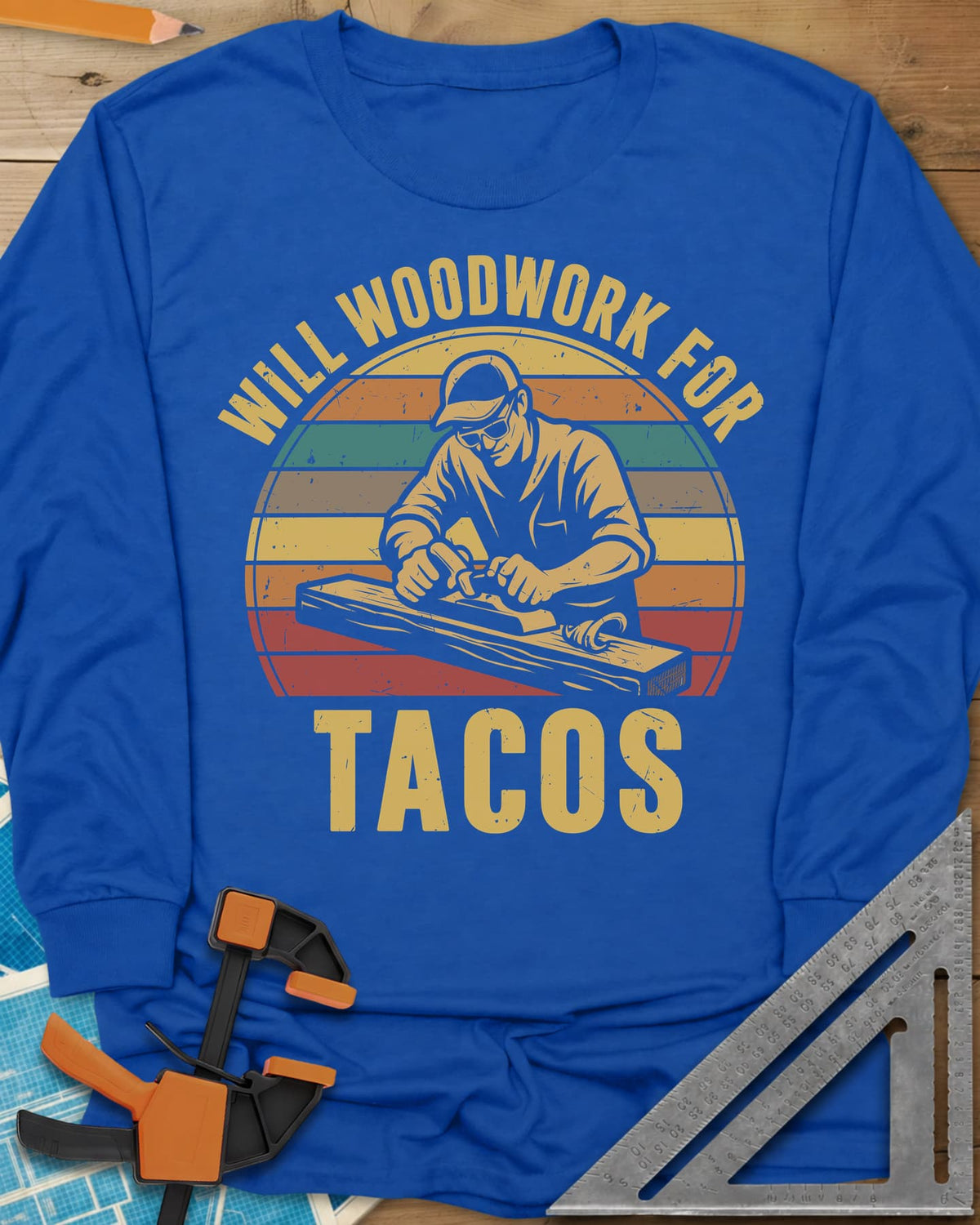 Will Woodwork For Tacos long sleeve shirt in Royal, a capped woodworker planing a board before retro sunset stripes