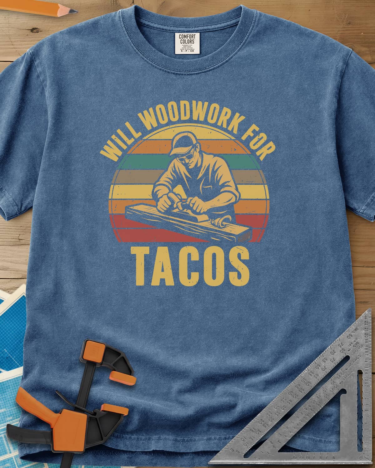 Will Woodwork For Tacos heavyweight tee in Blue Jean, a capped woodworker planing a board before retro sunset stripes