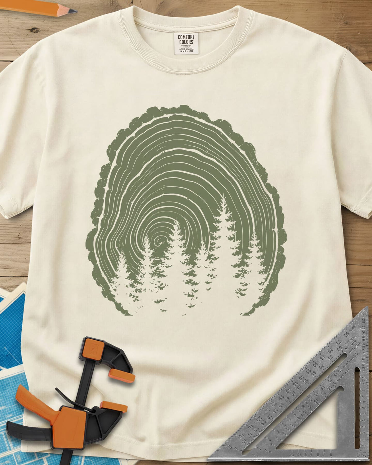 Wood Grain Forest heavyweight tee in Ivory, cut log tree rings with a stand of pine trees inside