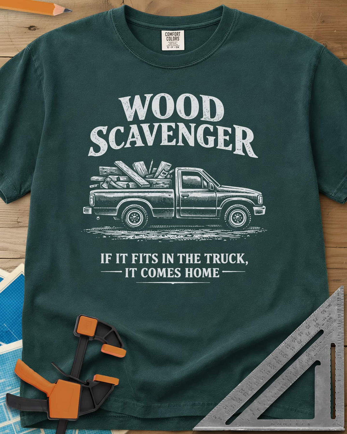 Wood Scavenger heavyweight tee in Blue Spruce, a pickup truck loaded with boards, offcuts and an axe