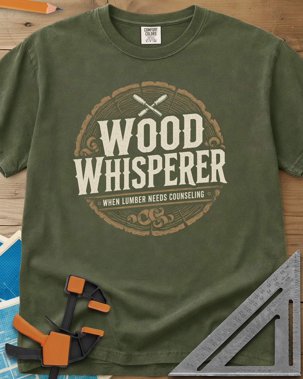 Wood Whisperer heavyweight tee in Hemp, a round log-slice badge with crossed chisels and shaving curls