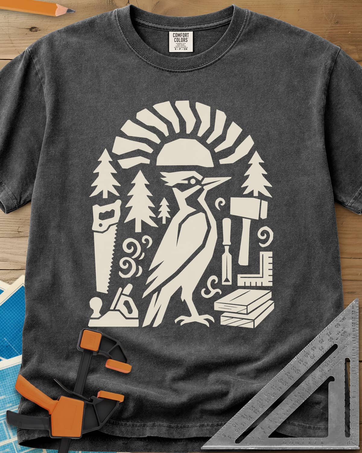 Woodpecker Craft heavyweight tee in Pepper, a geometric woodpecker among saws, planes, chisels and pine trees