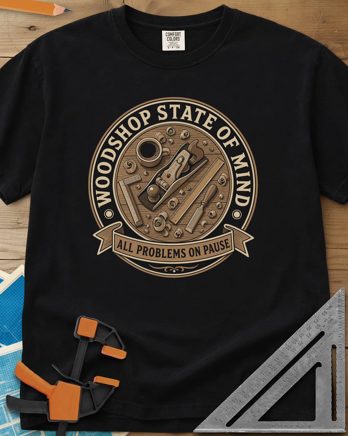 Woodshop State Of Mind heavyweight tee in Black, a round badge of a hand plane, coffee, chisel and shavings on a bench