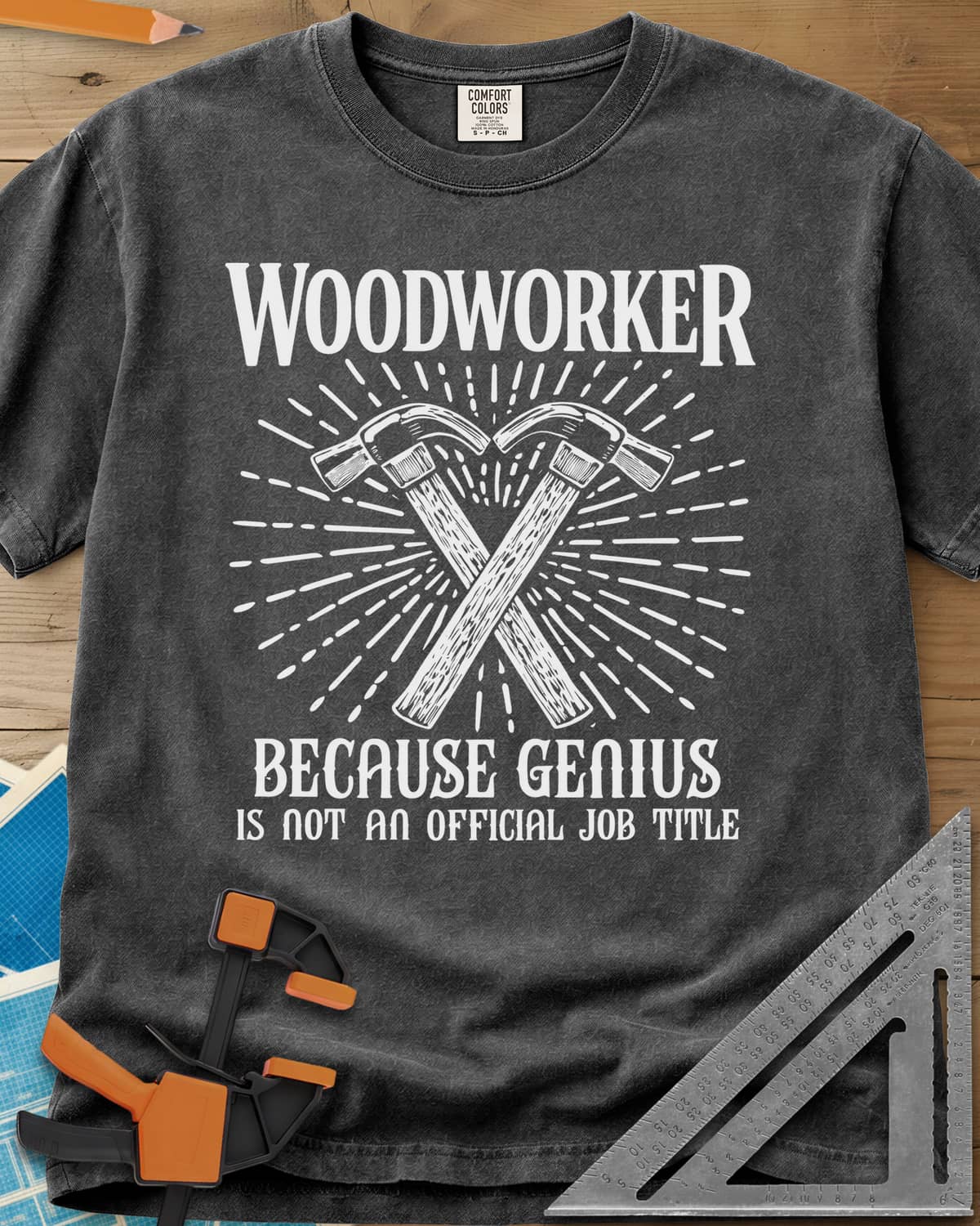 Woodworker Because Genius heavyweight tee in Pepper, two crossed hammers inside a sunburst of fine lines
