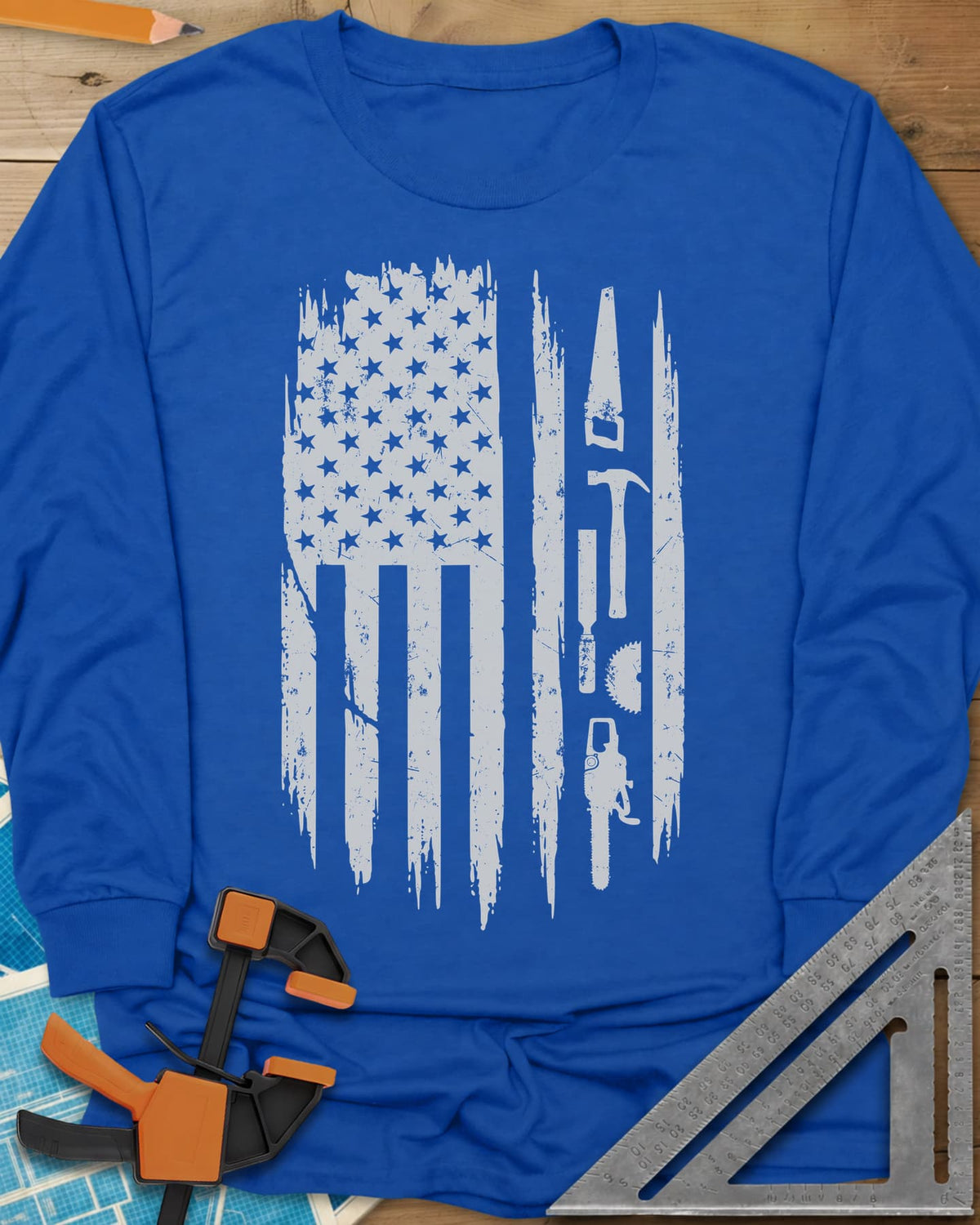 Woodworker Flag long sleeve shirt in Royal, a distressed American flag with a hand saw, hammer and chainsaw