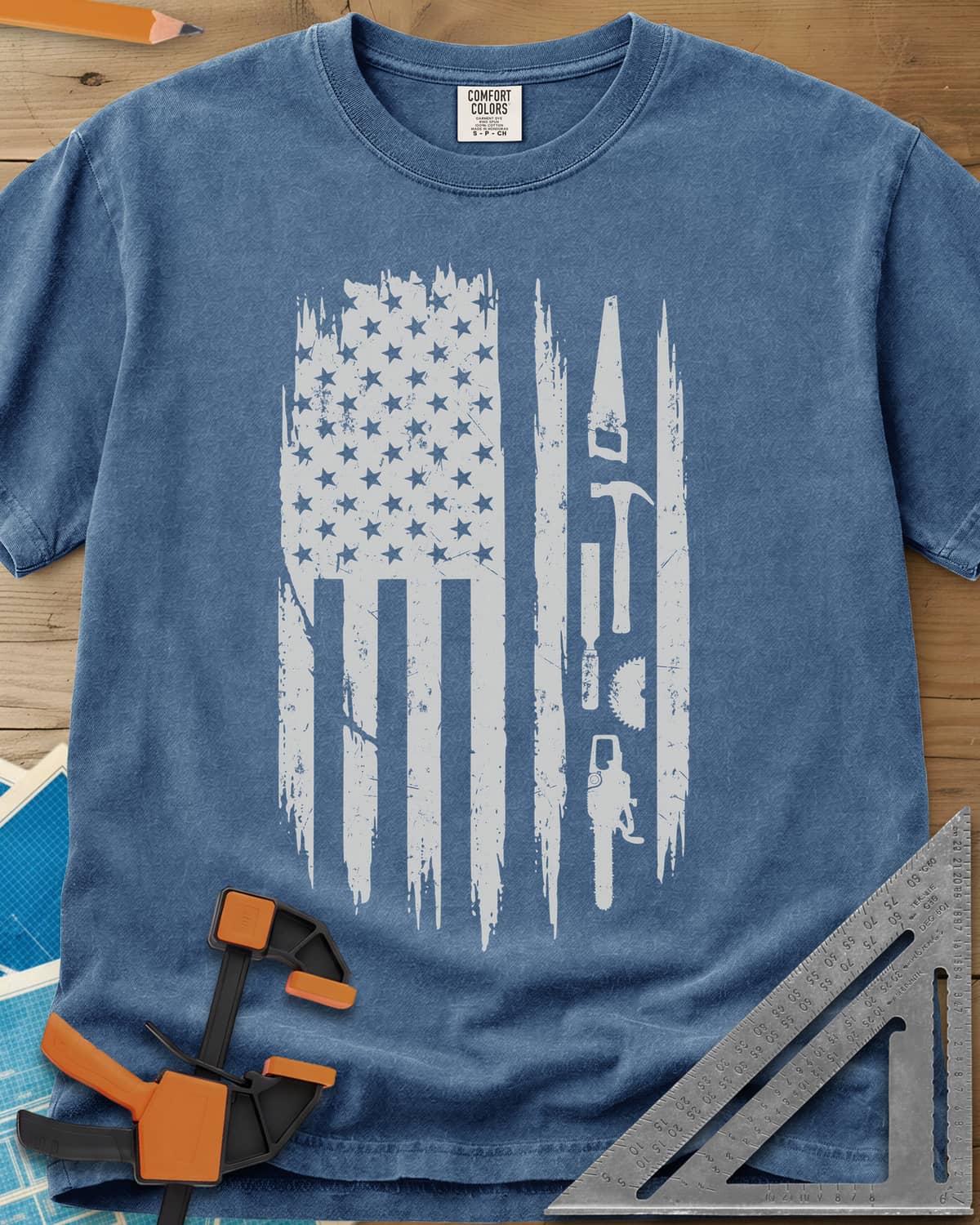 Woodworker Flag heavyweight tee in Blue Jean, a distressed American flag with a hand saw, hammer and chainsaw