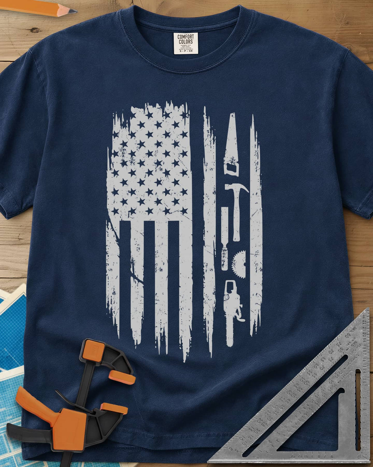 Woodworker Flag heavyweight tee in Navy, a distressed American flag with a hand saw, hammer and chainsaw
