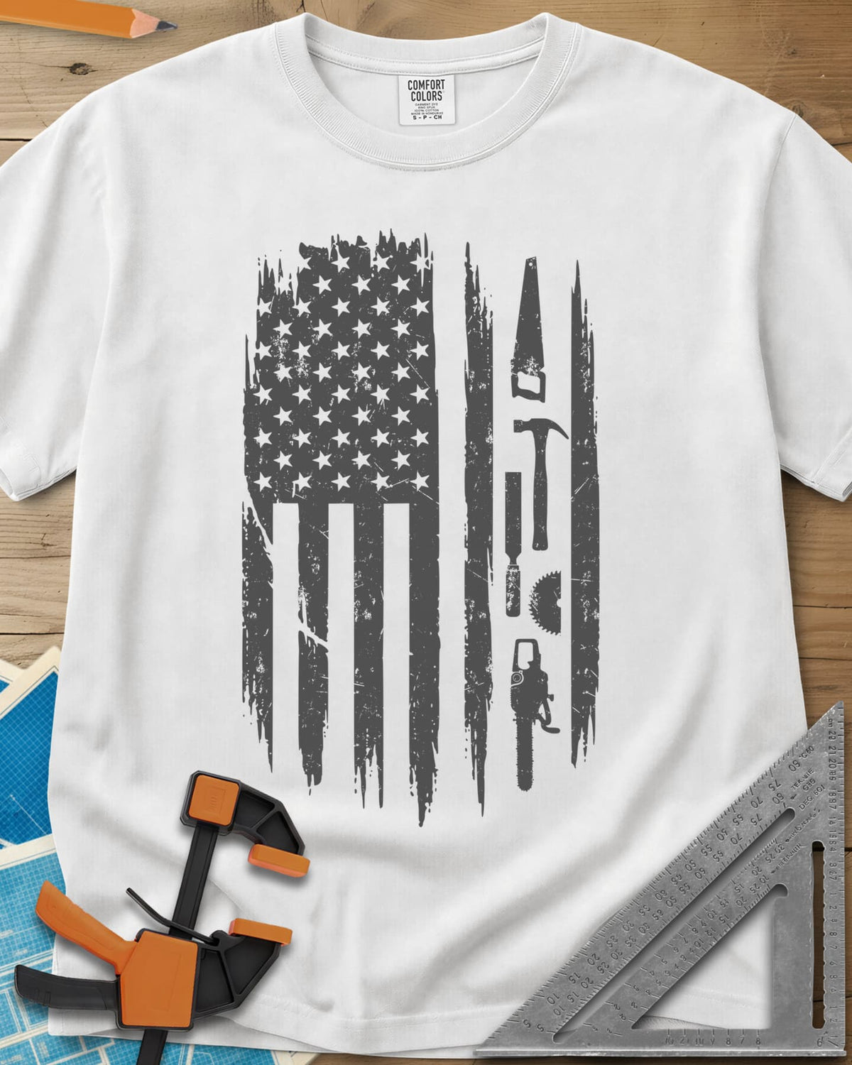 Woodworker Flag heavyweight tee in White, a distressed American flag with a hand saw, hammer and chainsaw
