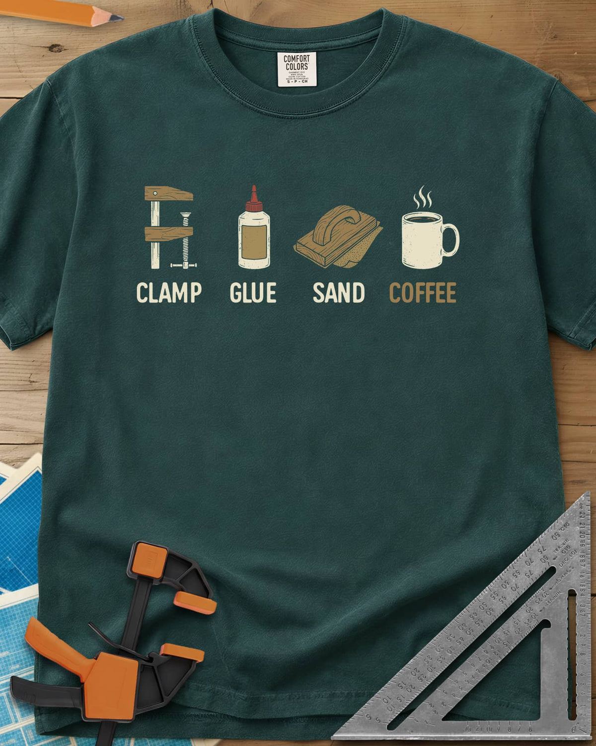 Woodworker's Essentials heavyweight tee in Blue Spruce, a bar clamp, glue bottle, sanding block and mug, each captioned