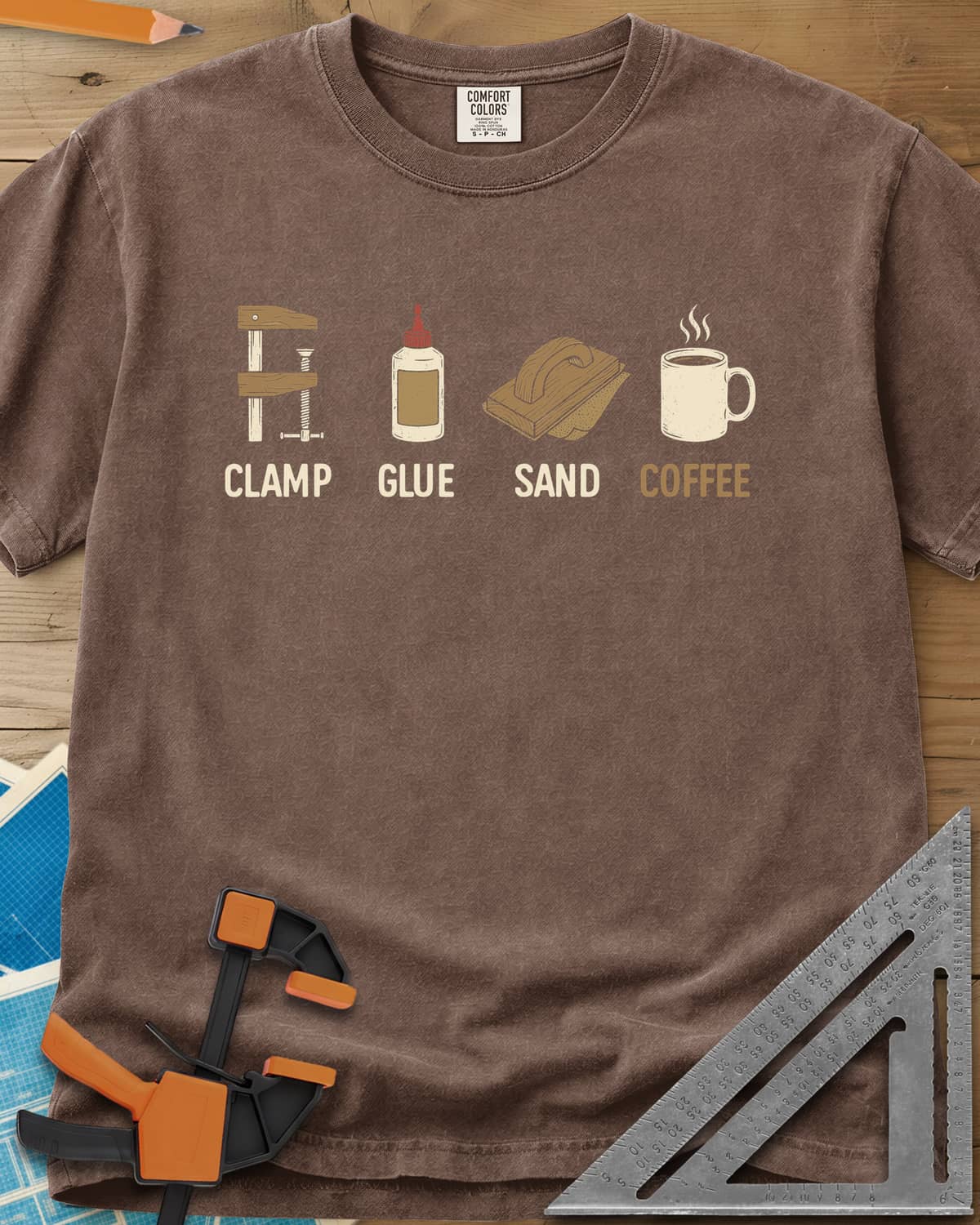 Woodworker's Essentials heavyweight tee in Espresso, a bar clamp, glue bottle, sanding block and mug, each captioned