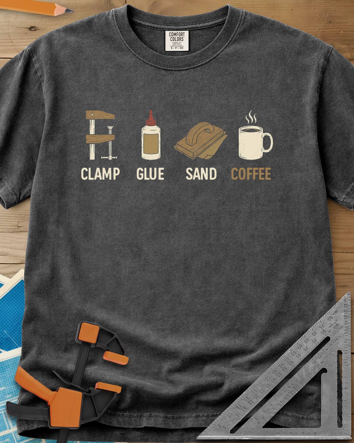 Woodworker's Essentials heavyweight tee in Pepper, a bar clamp, glue bottle, sanding block and mug, each captioned