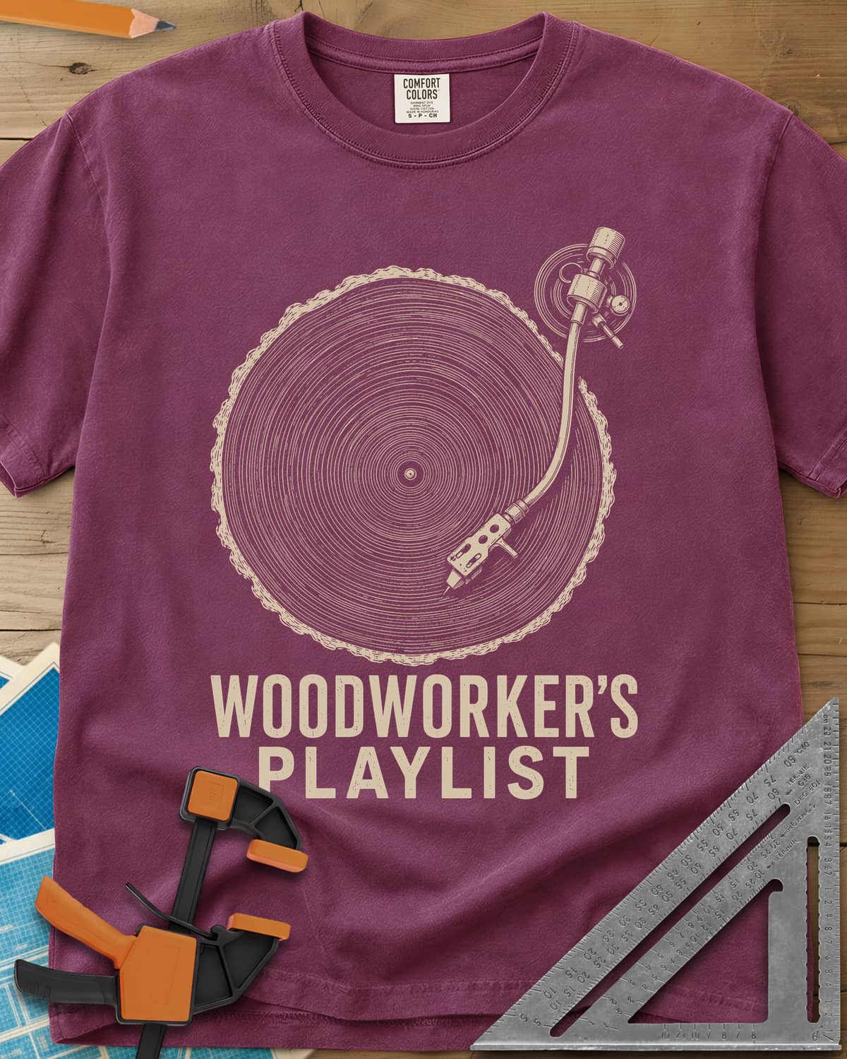 Woodworker’s Playlist heavyweight tee in Berry, tree-ring slice as a vinyl record with a turntable tonearm