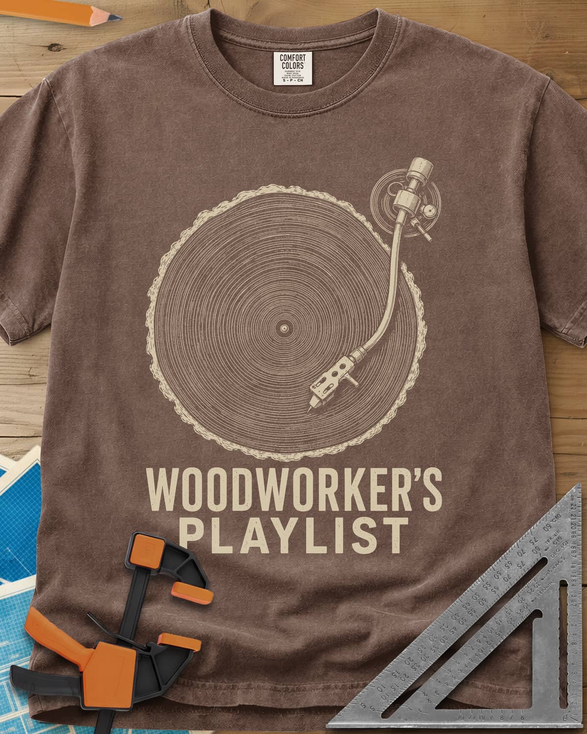 Woodworker’s Playlist heavyweight tee in Espresso, tree-ring slice as a vinyl record with a turntable tonearm