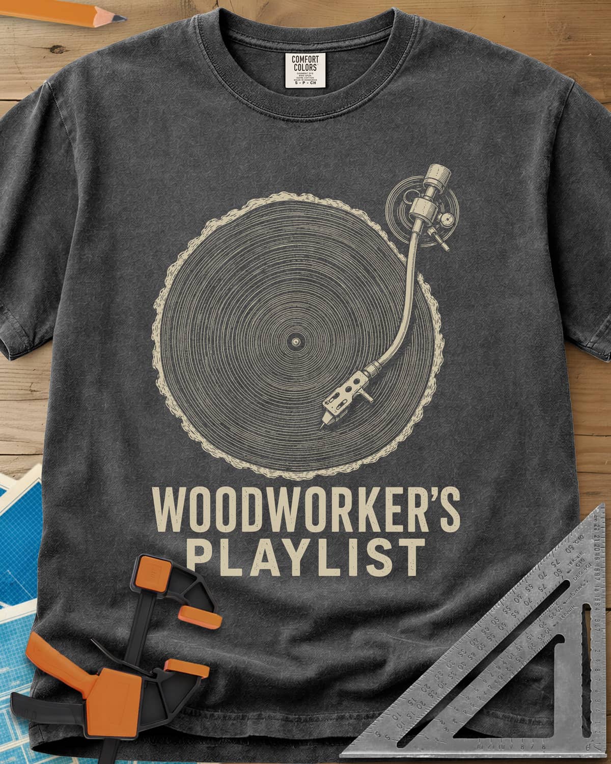 Woodworker’s Playlist heavyweight tee in Pepper, tree-ring slice as a vinyl record with a turntable tonearm