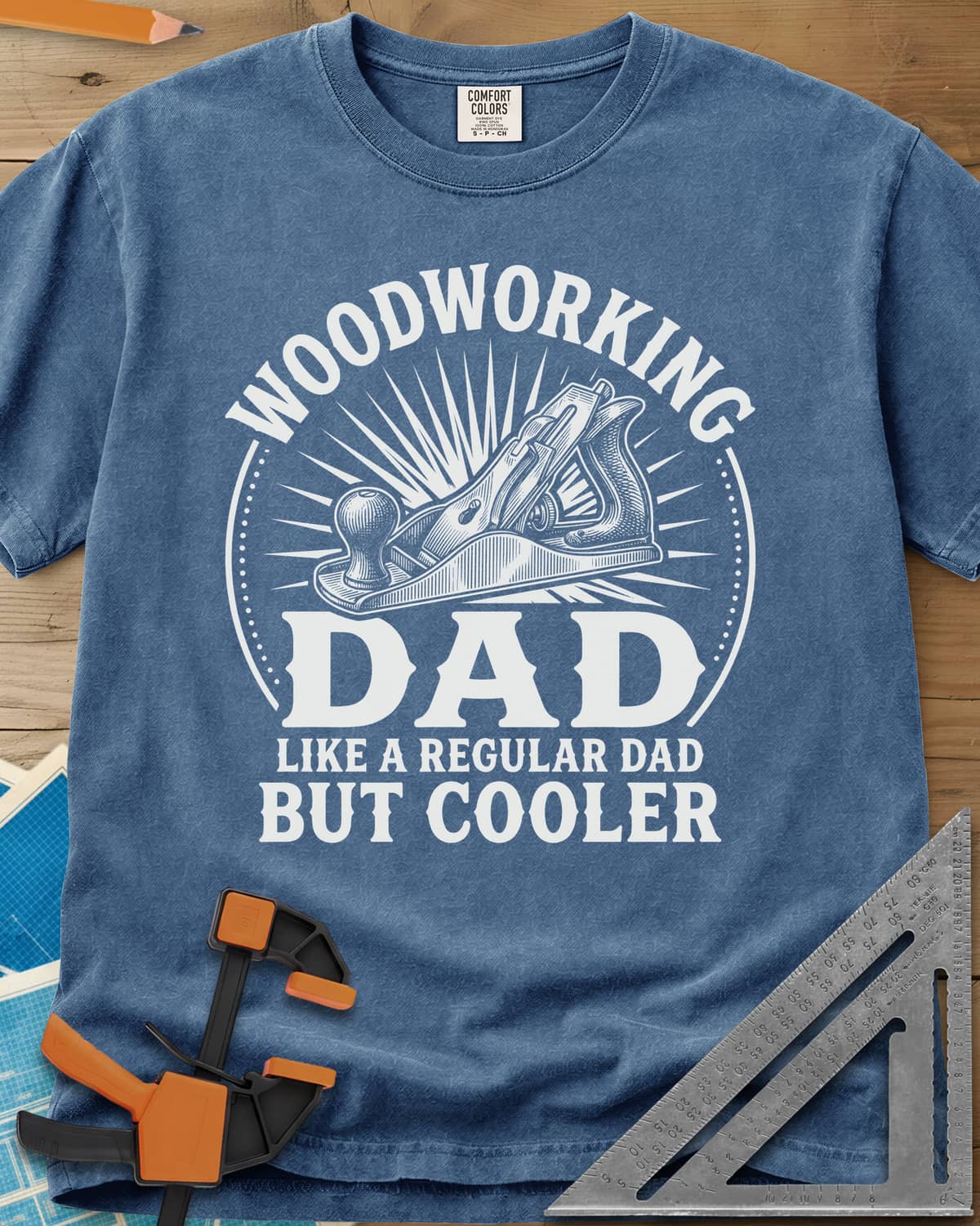 Woodworking Dad But Cooler heavyweight tee in Blue Jean, an engraved hand plane in a sunburst circle