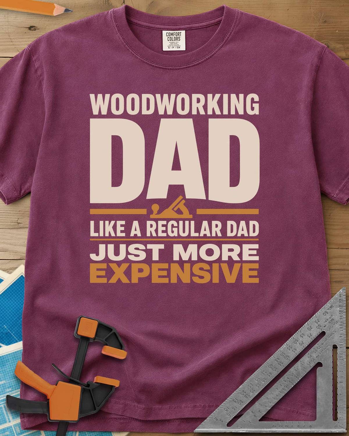 Woodworking Dad Just More Expensive heavyweight tee in Berry, bold lettering with a small hand plane tucked under DAD