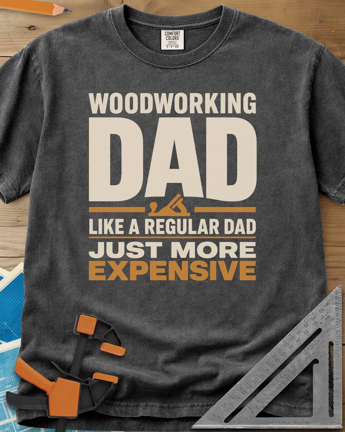 Woodworking Dad Just More Expensive heavyweight tee in Pepper, bold lettering with a small hand plane tucked under DAD