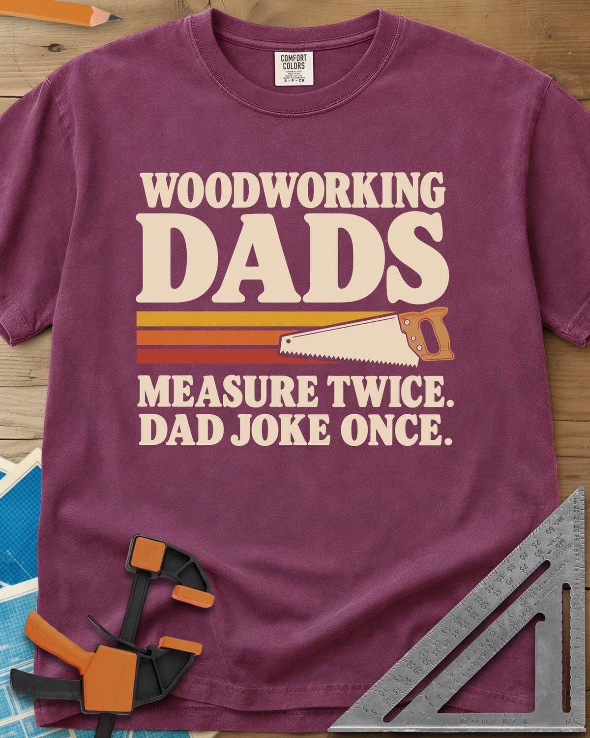 Woodworking Dads heavyweight tee in Berry, retro stripes trailing a hand saw under bold type