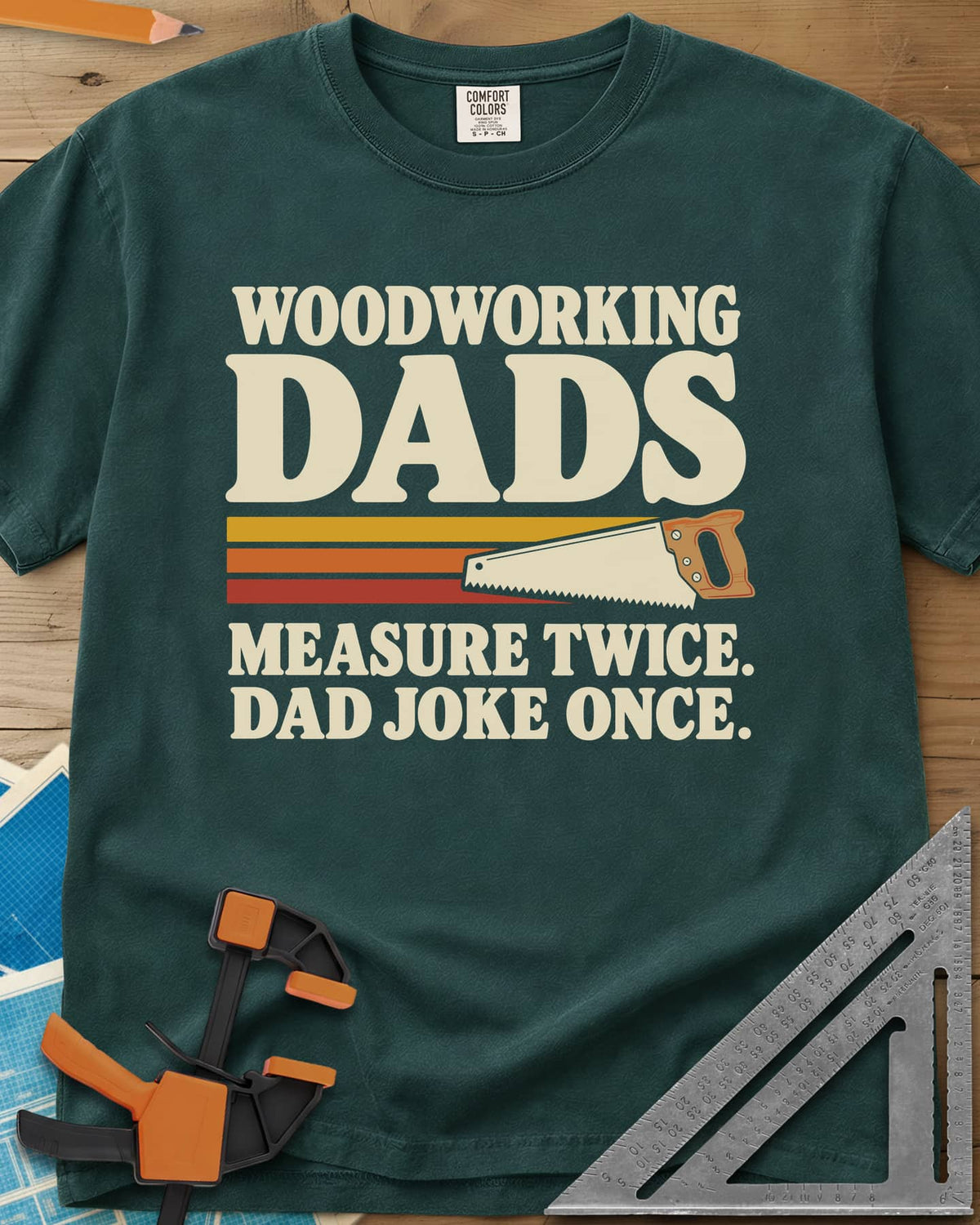 Woodworking Dads heavyweight tee in Blue Spruce, retro stripes trailing a hand saw under bold type