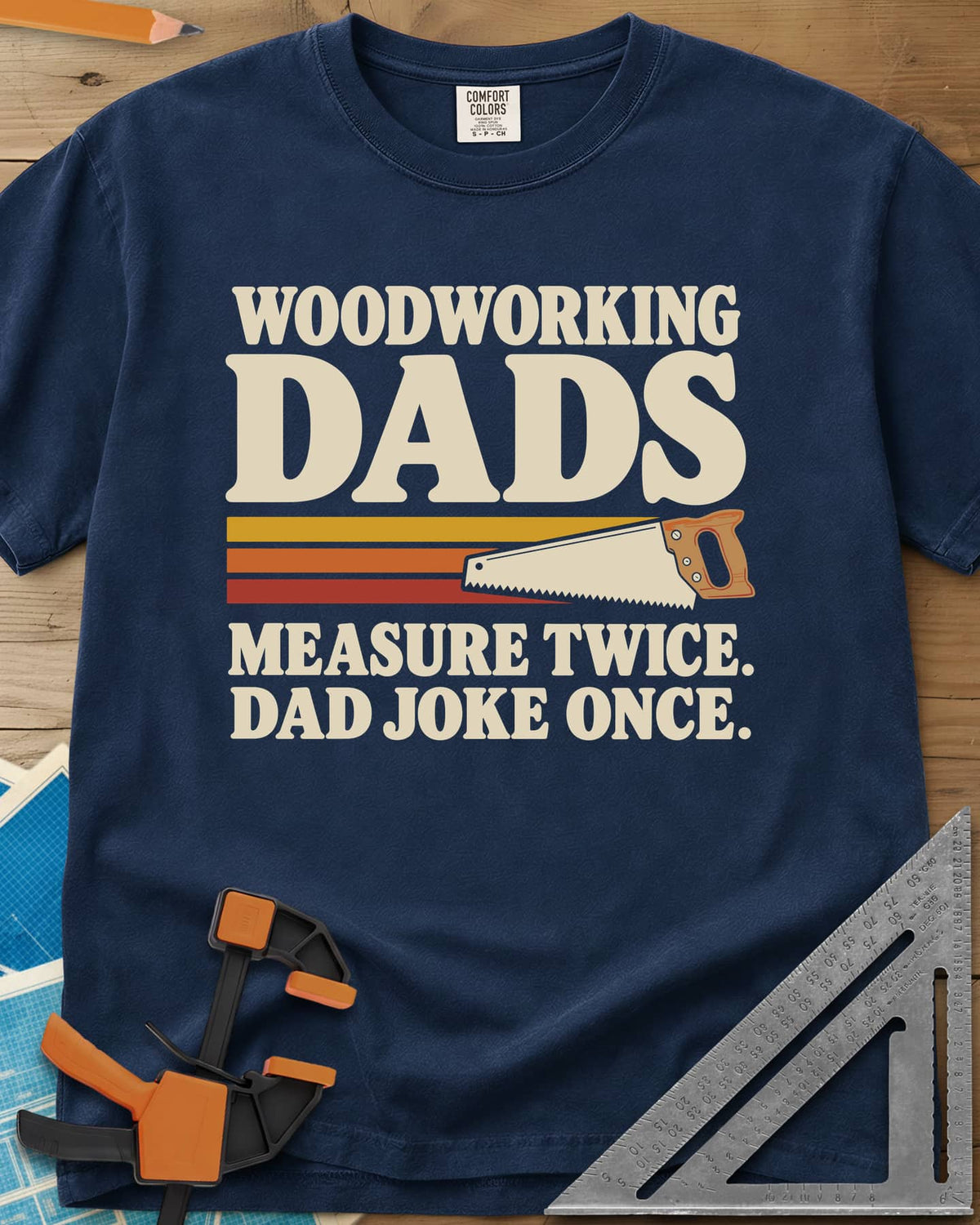 Woodworking Dads heavyweight tee in Navy, retro stripes trailing a hand saw under bold type