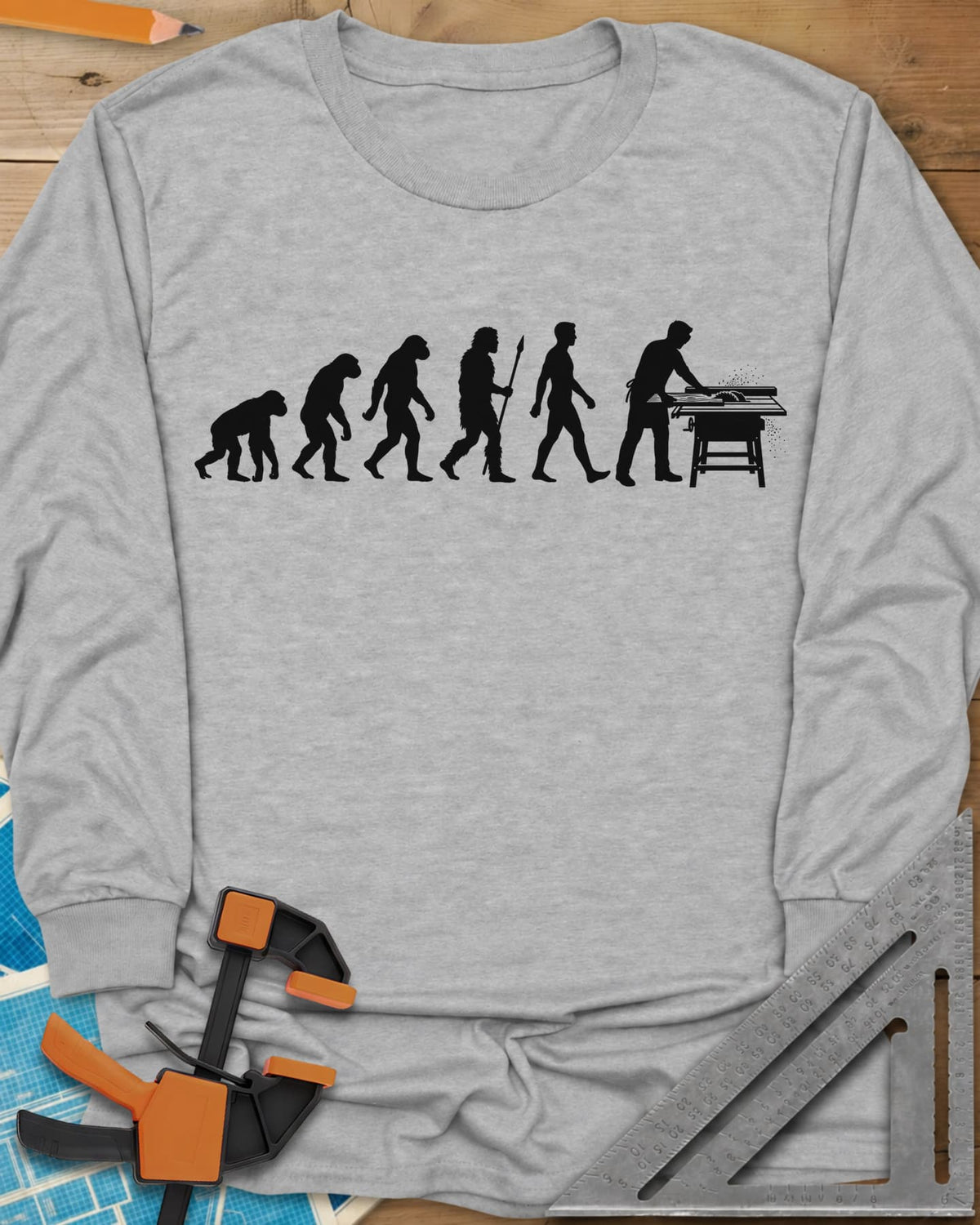 Woodworking Evolution long sleeve shirt in Sport Grey, six white silhouettes from an ape to a man at a table saw