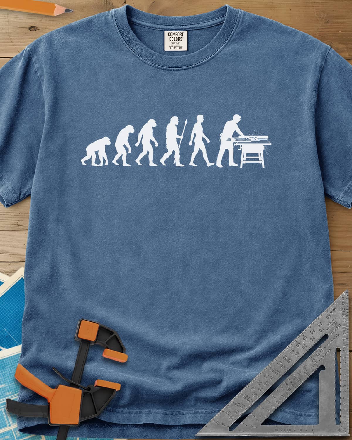 Woodworking Evolution heavyweight tee in Blue Jean, six white silhouettes from an ape to a man at a table saw