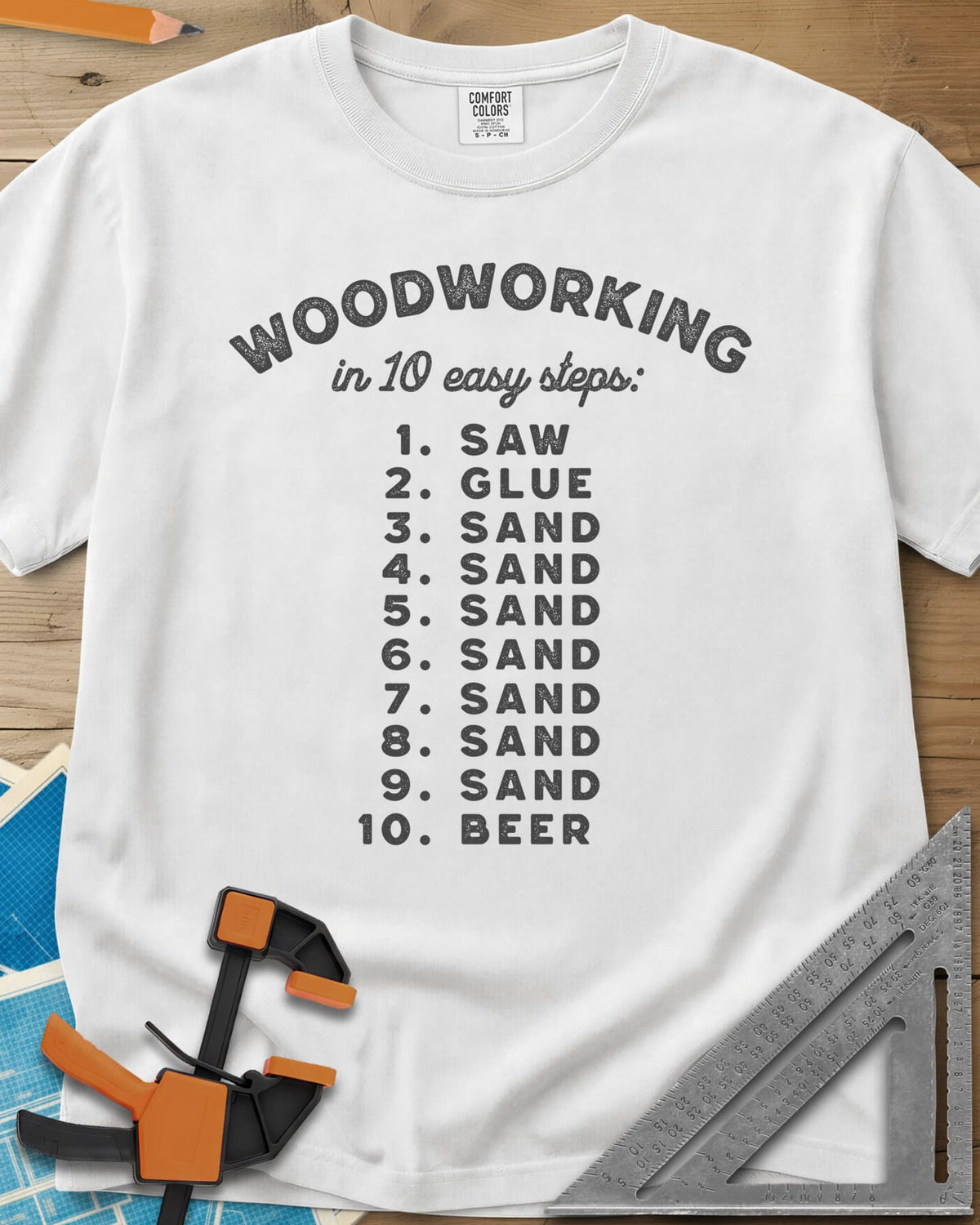 Woodworking in 10 Easy Steps heavyweight tee in White, a numbered list: saw, glue, sand seven times, then beer