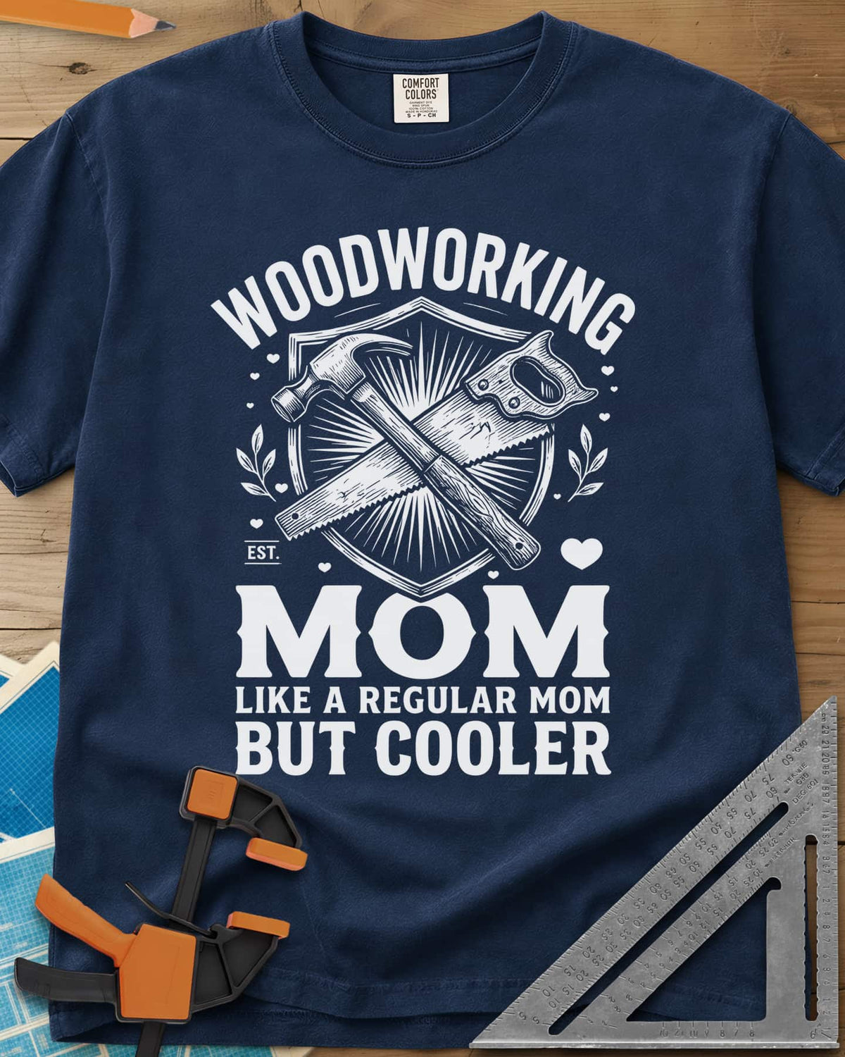 Woodworking Mom heavyweight tee in Navy, a hammer and hand saw crossed on a shield with hearts and leaves
