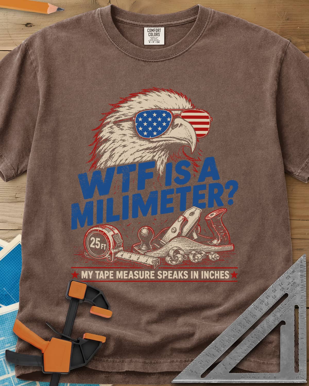 WTF Is A Millimeter heavyweight tee in Espresso, an eagle in flag sunglasses above a hand plane and 25 ft tape