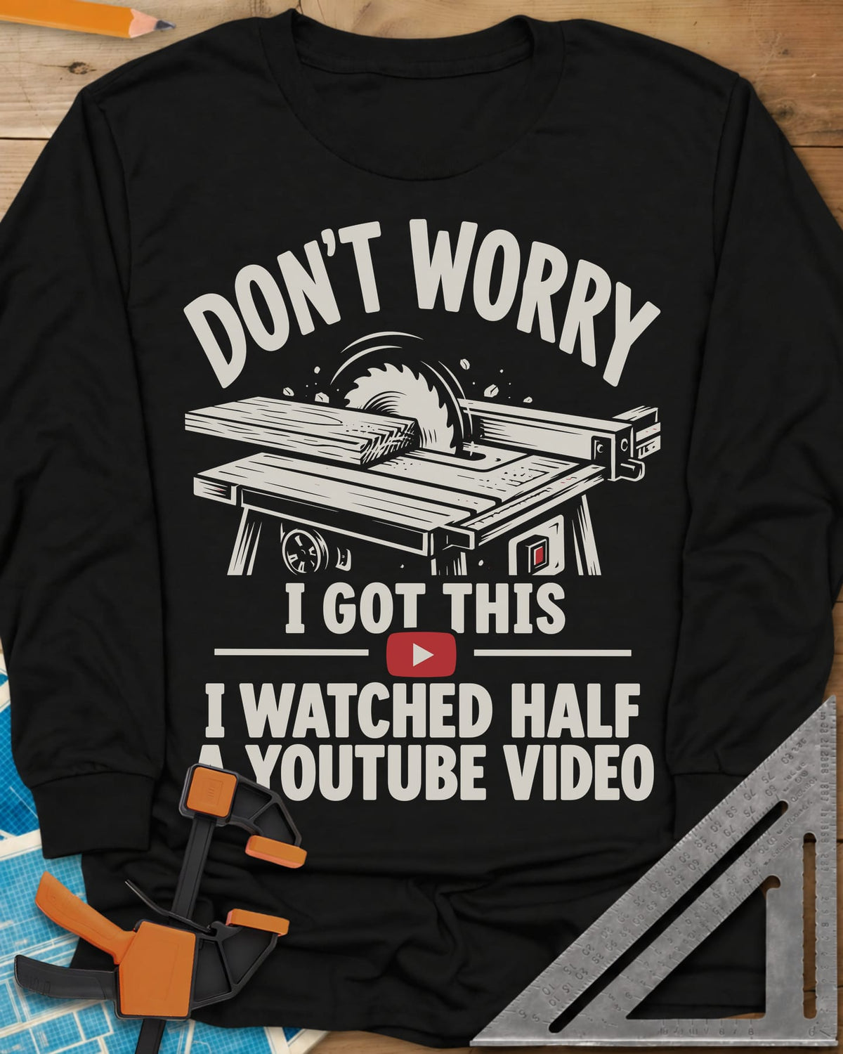 YouTube Video long sleeve shirt in Black, a table saw with a board at the blade above a red play button