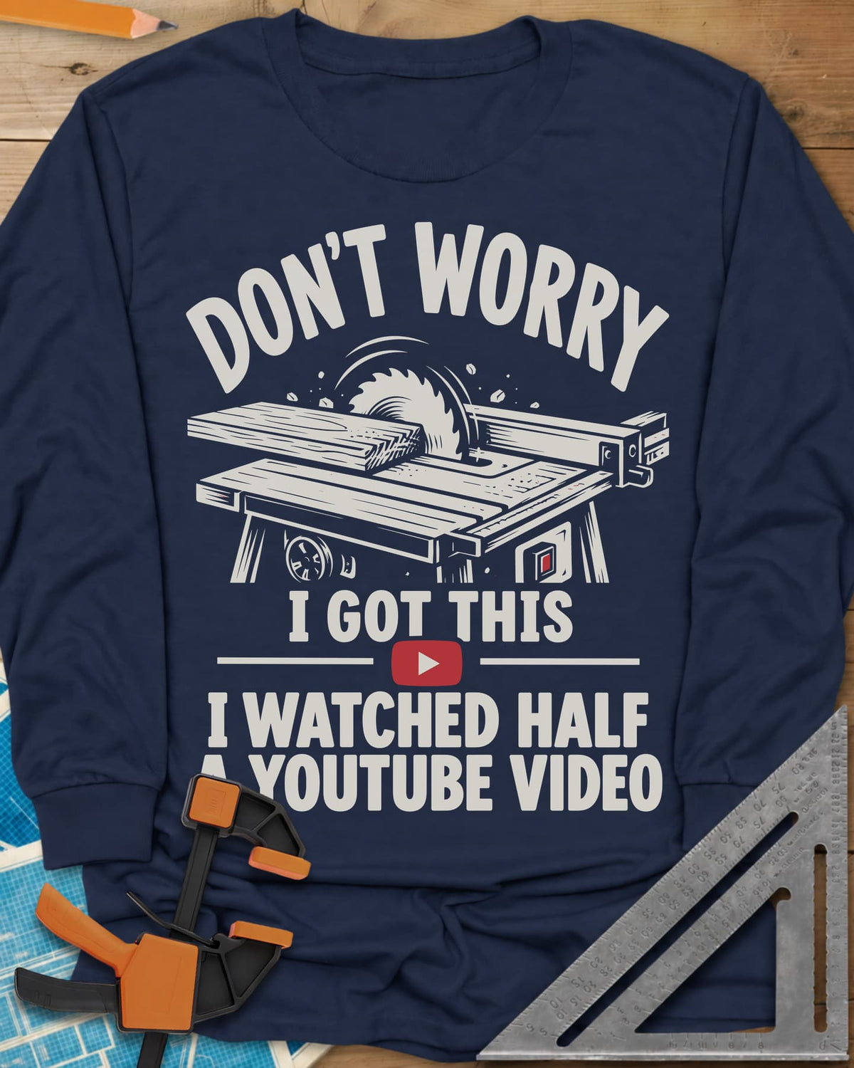 YouTube Video long sleeve shirt in Navy, a table saw with a board at the blade above a red play button